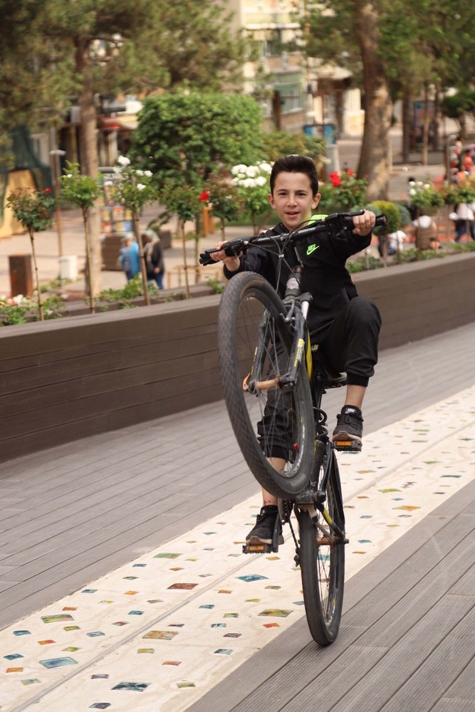 45-HAMAMYOLU URBAN DECK-young bicycle rider rearing up on the art bridge ramp.jpg